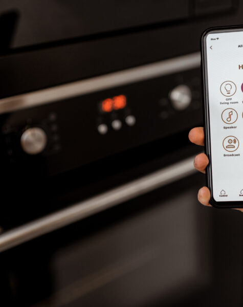 Controlling smart kitchen appliance with mobile application Controlling smart kitchen appliance using mobile phone at home, close-up on mobile screen. Concept of a smart home and managing home with mobile devices