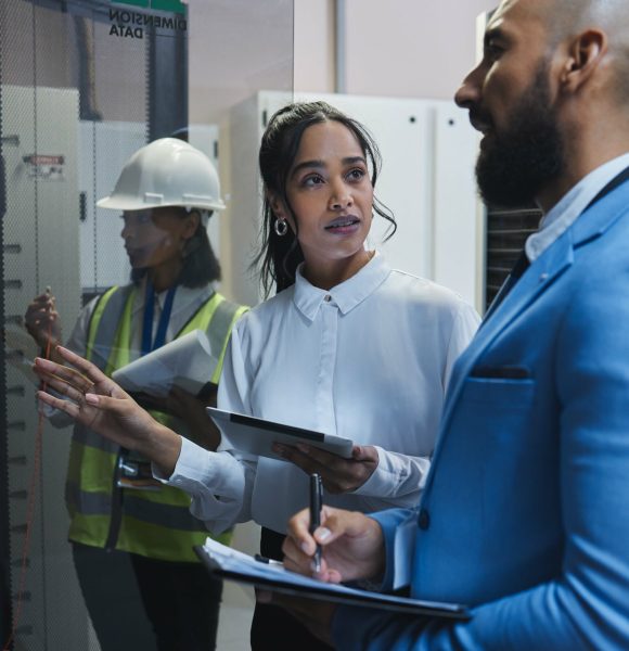 Shot of two workers inspecting the electronic equipment in a server room together at work.